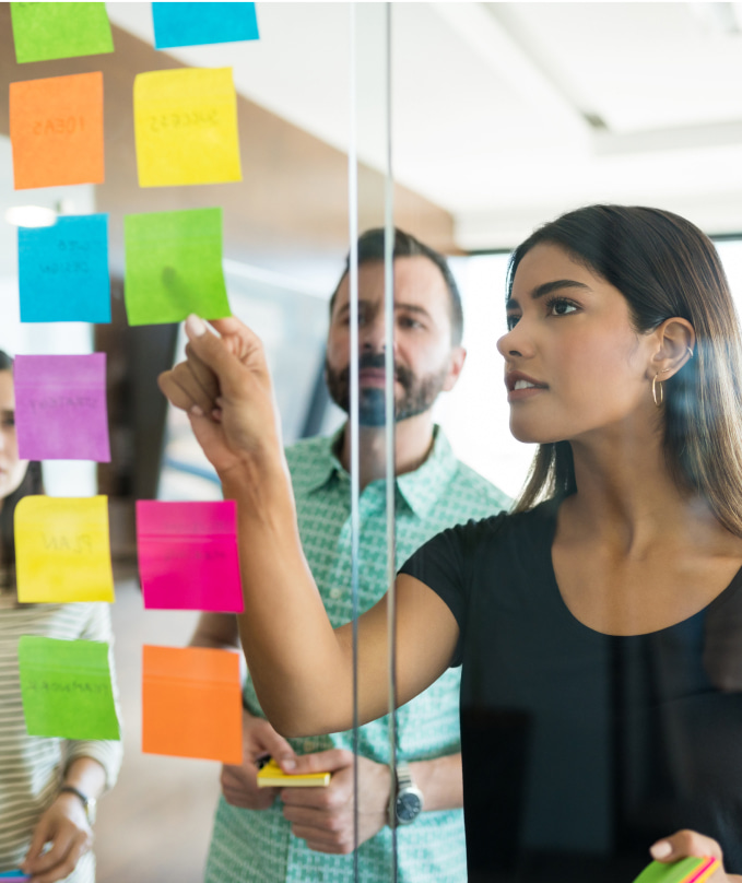 female young manager discussing adhesive note with coworkers office meeting 1 min